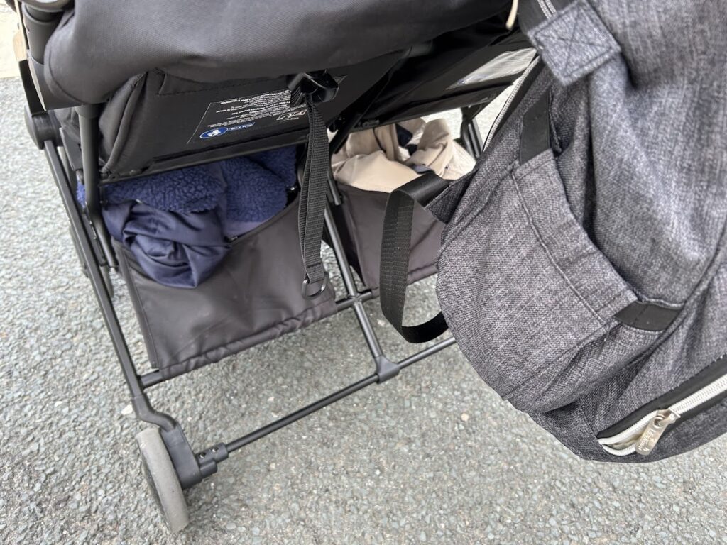 Pushchair underseat storage baskets in use on a train journey