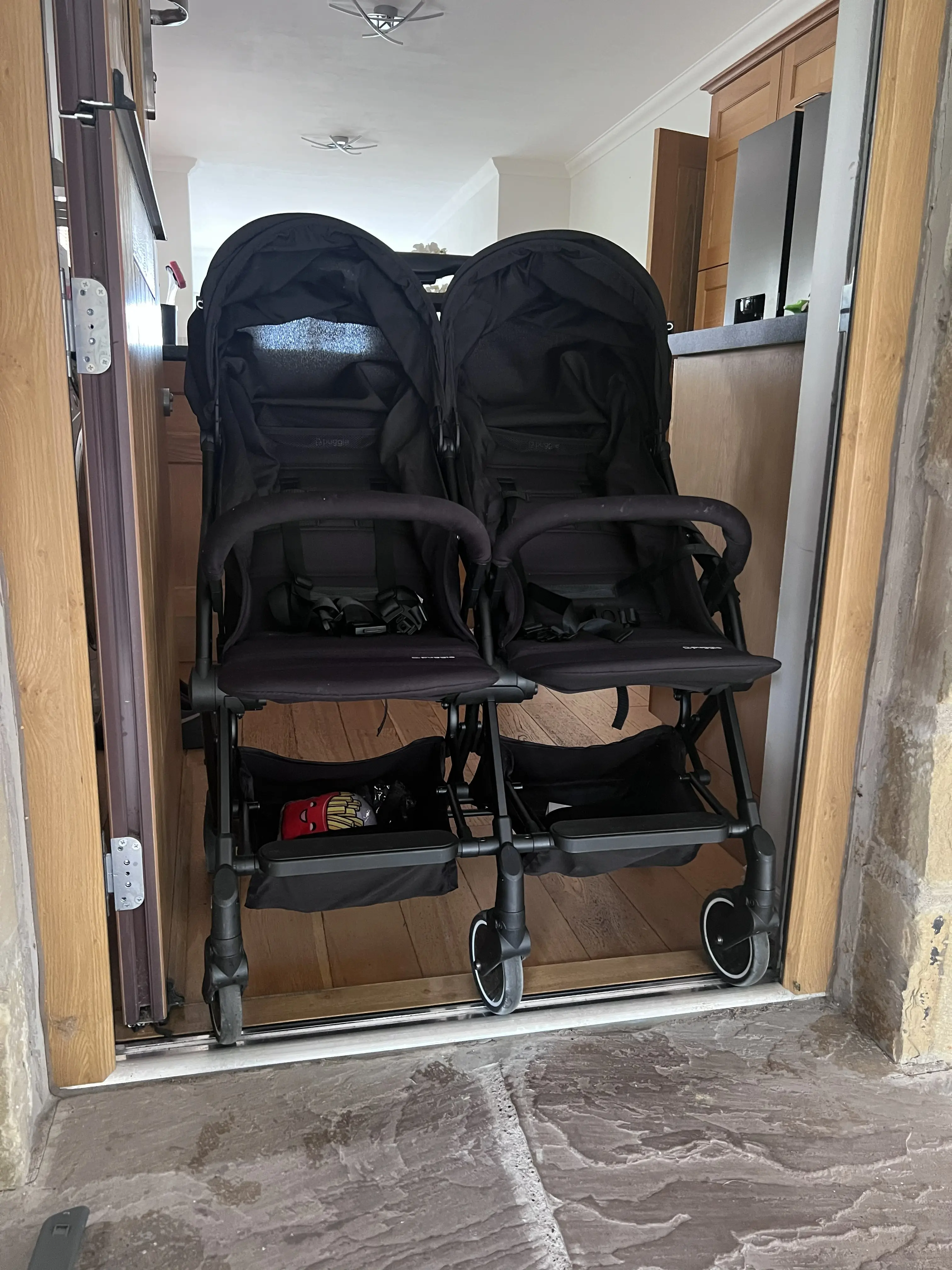 Puggle City Traveller double pushchair in front doorway showing width