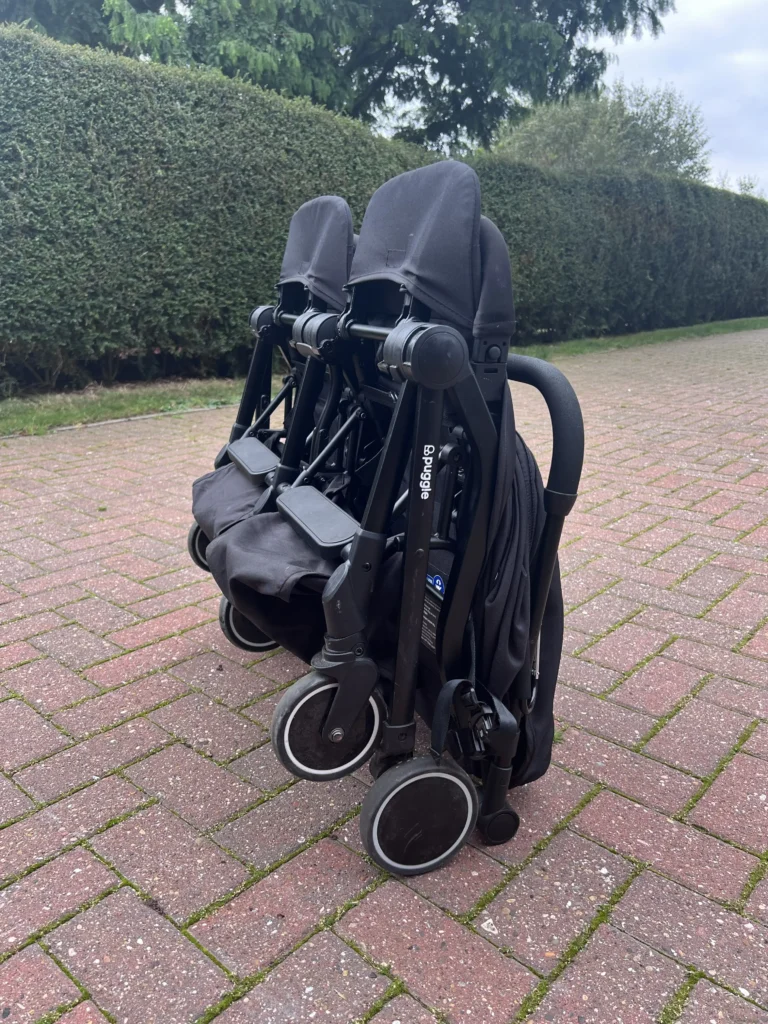 Puggle City Traveller double pushchair folded and standing upright on driveway in Wooler Northumberland